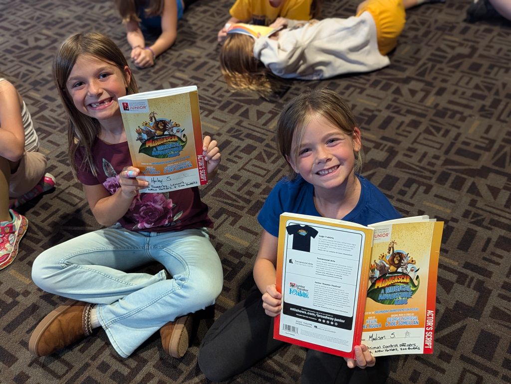 Hailey S. (left) and Madison S., two of 42 students participating in Woodlawn Arts Academy’s fall musical theater production, show off their scripts during a rehearsal. “Madagascar: A Musical Adventure Kids” will be performed the weekend of Oct. 9 at Centennial Auditorium at Sterling High School.